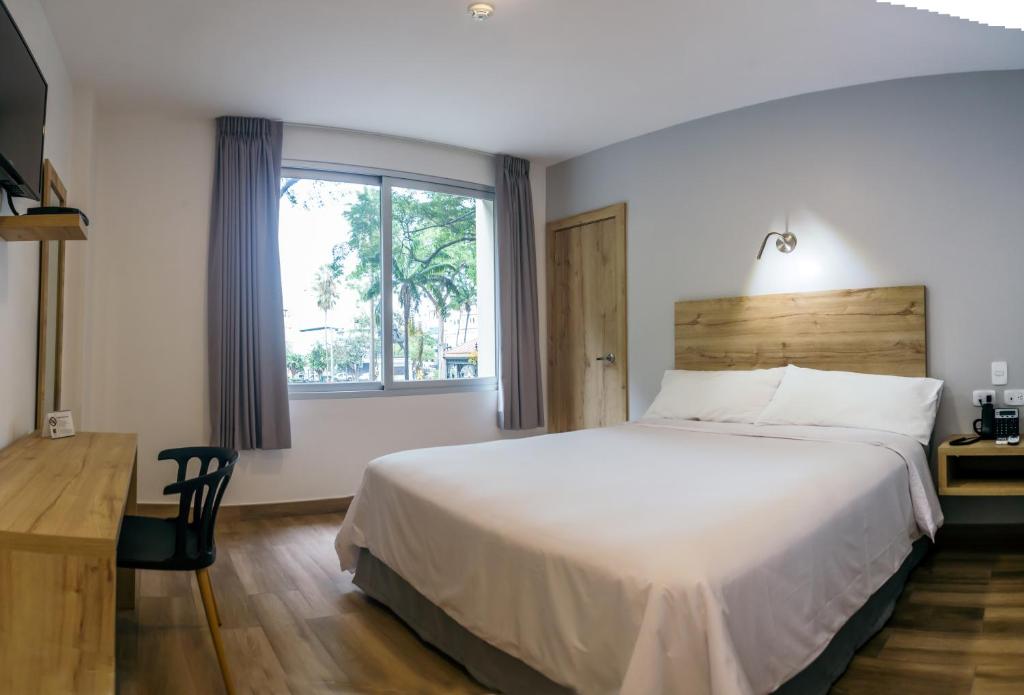 瓜亚基尔The Park Hotel的一间卧室设有一张大床和一个窗户。