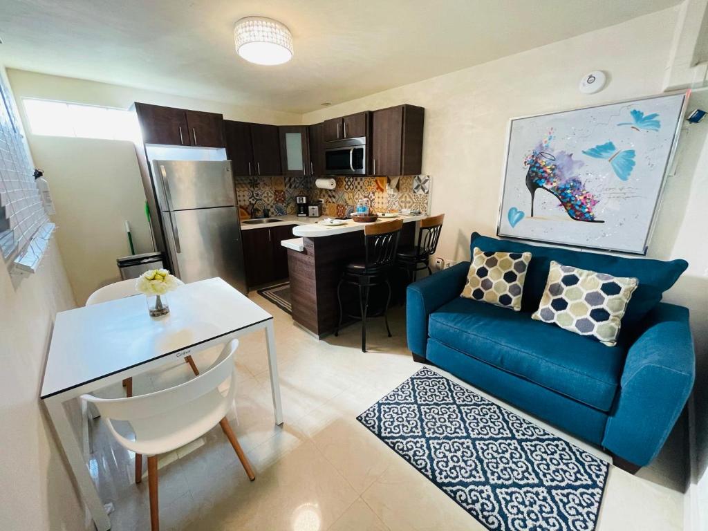 庞塞Charming Retreat with Patio Access的一间带蓝色沙发的客厅和一间厨房