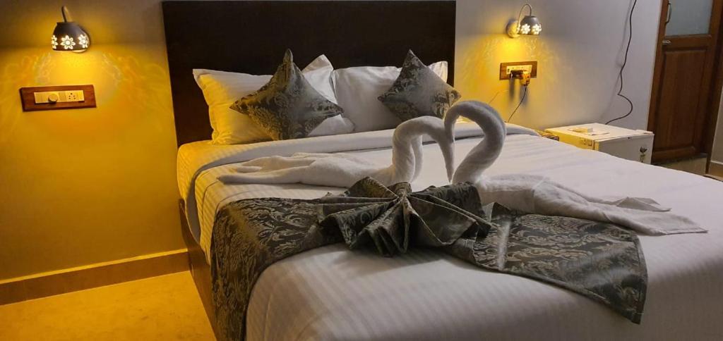 蓬蒂切里Le Supreme Inn (the lap of luxury)的一间卧室,床上配有2条天鹅毛巾