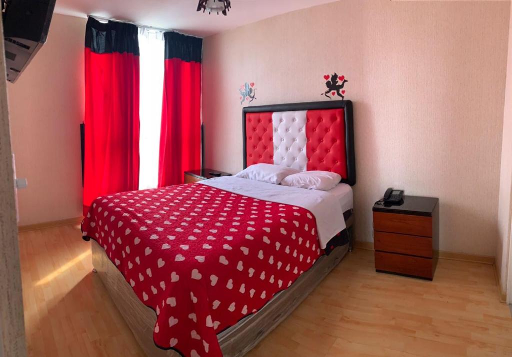 利马Peruvian Apartment的卧室配有红色和白色的床和红色窗帘