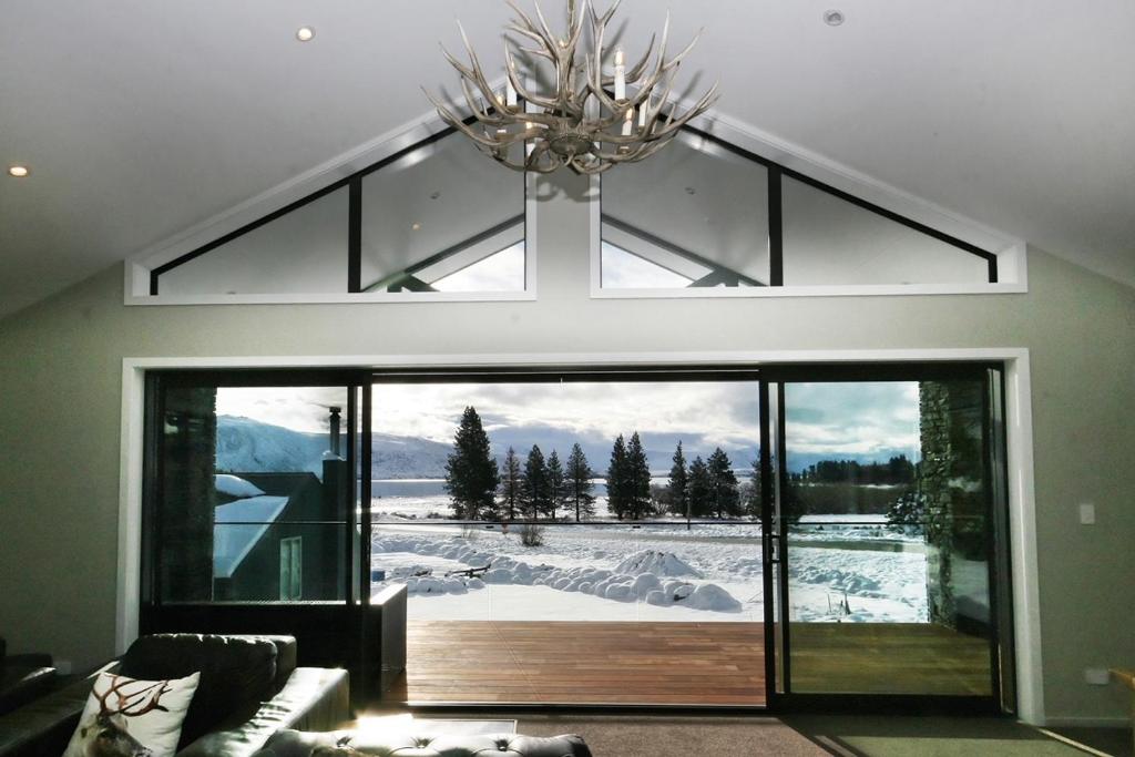 特卡波湖Lake Views at Antler Lodge的一间客厅,配有一个大玻璃门,享有美景
