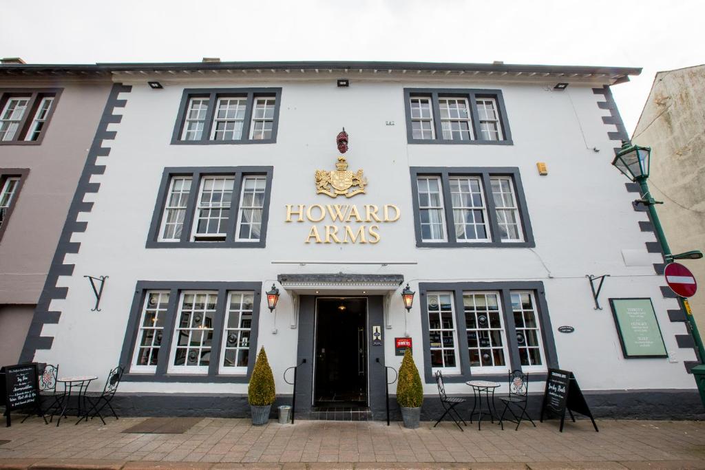 布兰普顿The Howard Arms的一座有标牌的建筑,上面有教养蜜主的手臂