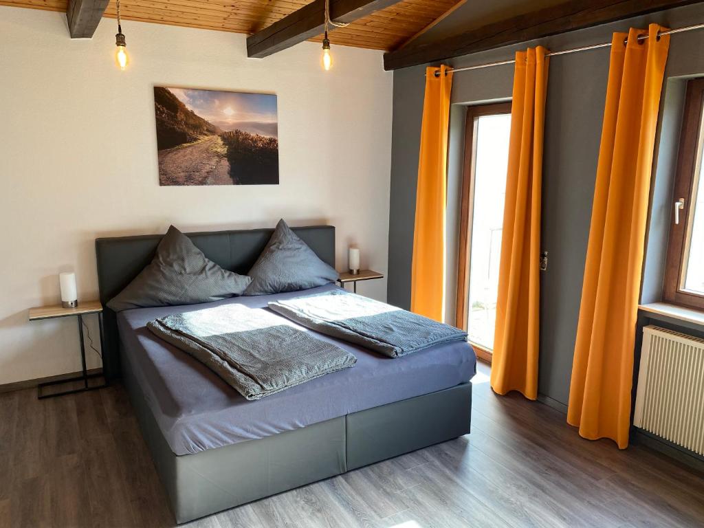 贝尔恩卡斯特尔-库斯Ferienweingut Peter-Jos. Hauth的一间卧室配有橙色窗帘的床