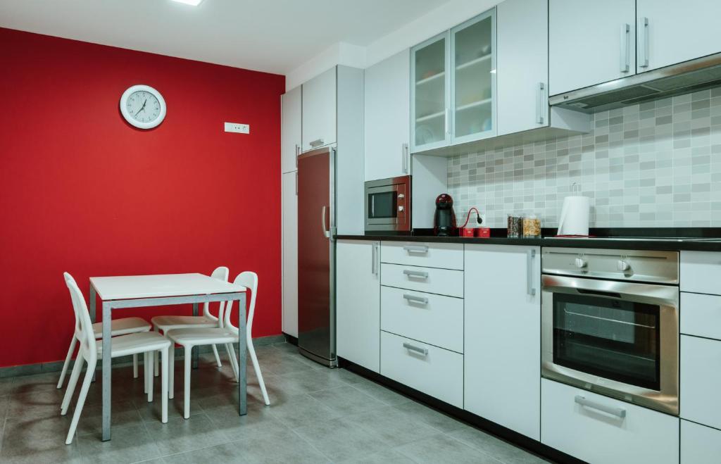 阿瓜尔达Apartamento nuevo al lado de la playa en A Guarda的厨房配有桌子和红色的墙壁