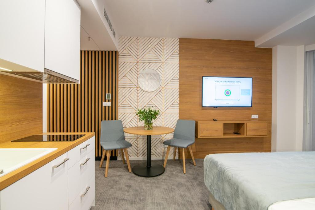 科沃布热格Seaside Apartaments Deluxe 627的一间卧室配有一张床、一张桌子和一台电视。