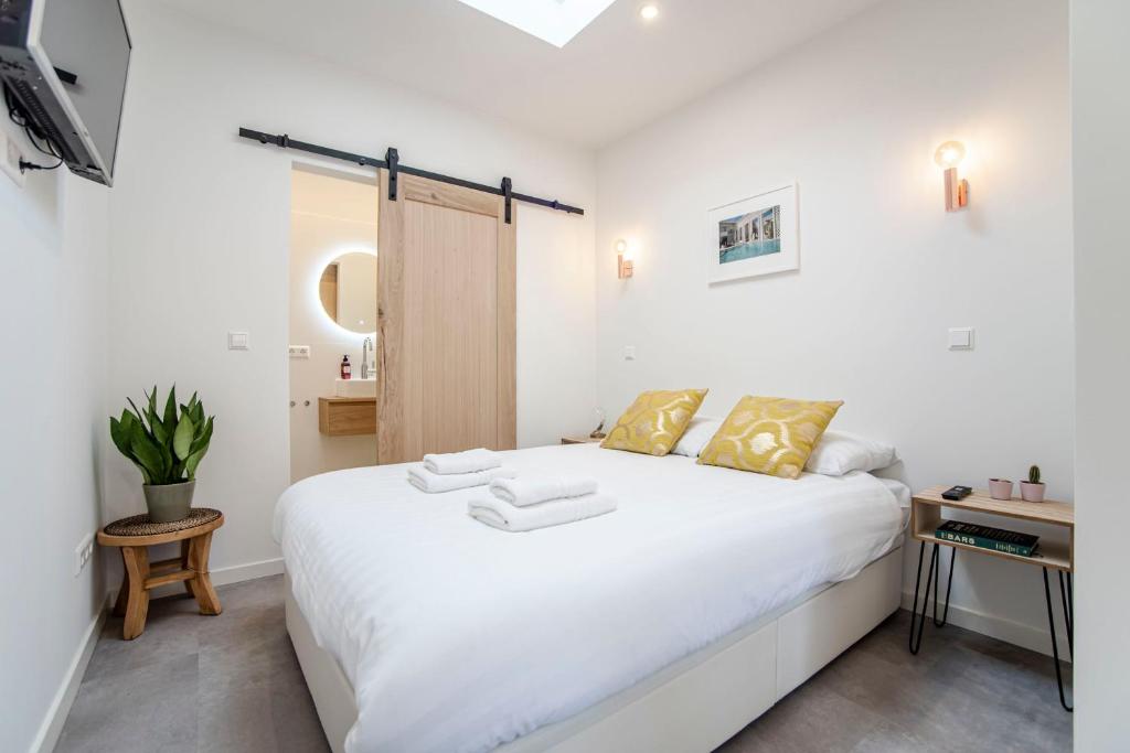 赞德沃特Beach Studio 35的卧室配有一张带黄色枕头的大型白色床。