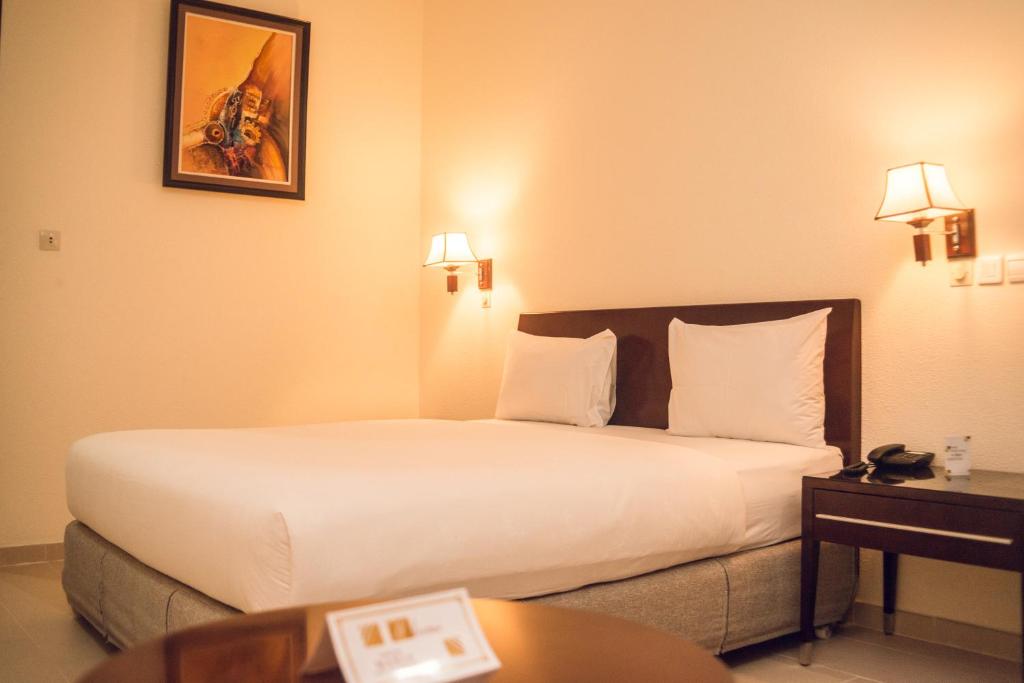 洛美Hôtel Sancta Maria的酒店客房设有一张大床和一张桌子。