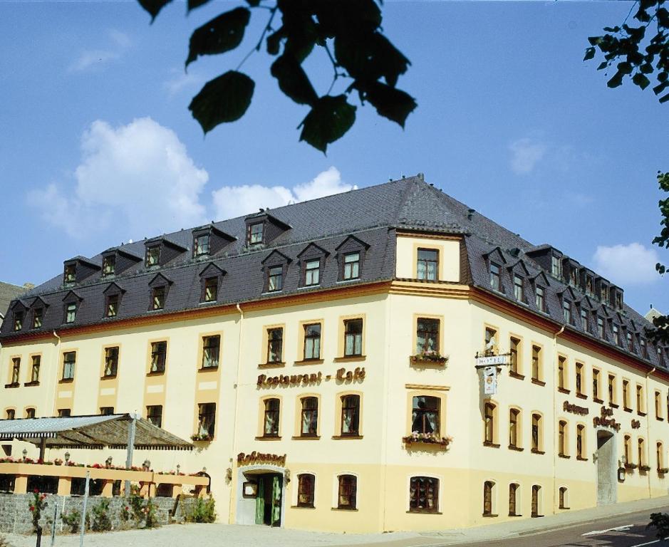 马林贝格威格斯罗格酒店的黑色屋顶的大型黄色建筑