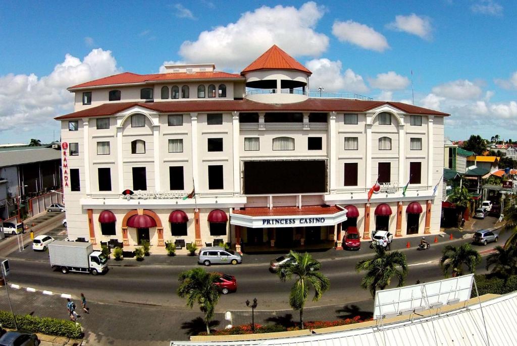帕拉马里博帕拉马里博公主华美达酒店的一条街道上一座白色的大建筑,有红色的屋顶