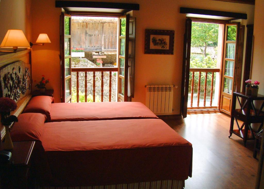 Quintana de Llanes阿尔达马高尔夫球酒店的一间卧室设有一张床,阳台设有推拉门