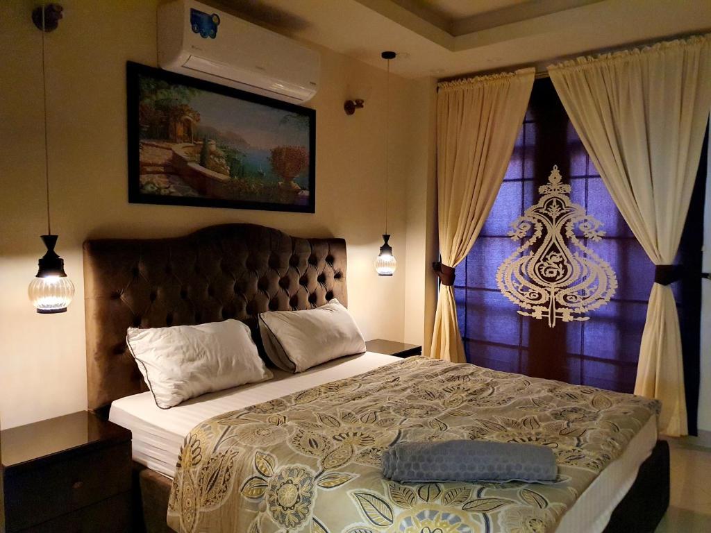 拉瓦尔品第The Millenial Apartments & Suites Bahria Town的一间卧室设有一张大床和一个窗户。