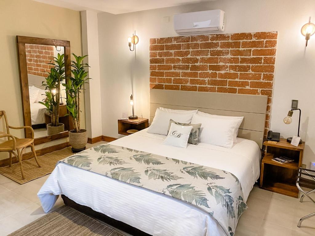 圣菲德安蒂奥基亚Casa Bixa Hotel Boutique - Solo Adultos的一间卧室设有一张床和砖墙