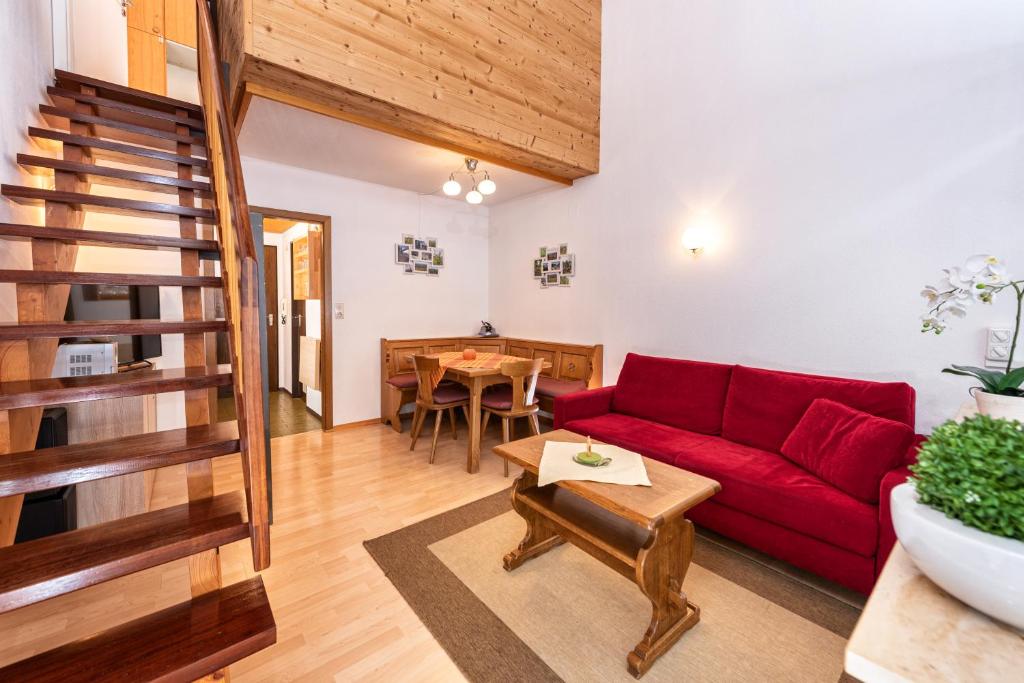 上施陶芬Imberg-Suite mit Schwimmbad的客厅配有红色的沙发和桌子