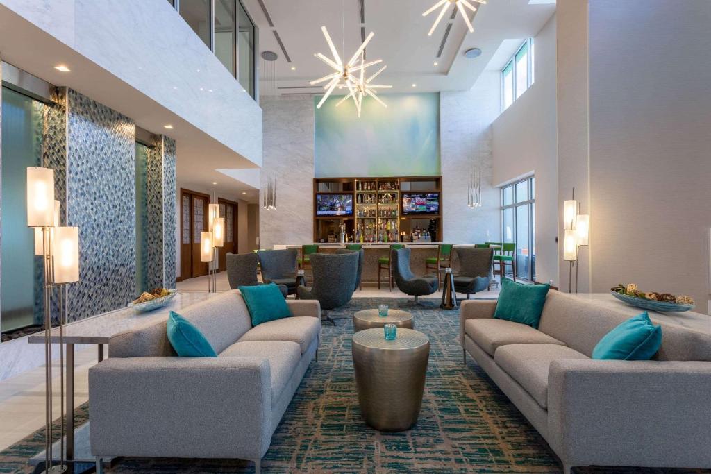 迈阿密Wyndham Garden Miami International Airport的酒店大堂里摆放着沙发和椅子