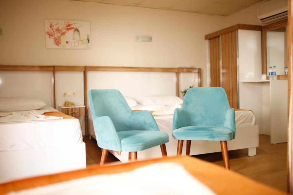 安塔利亚欧丈酒店的一间设有两张床和两张蓝色椅子的房间