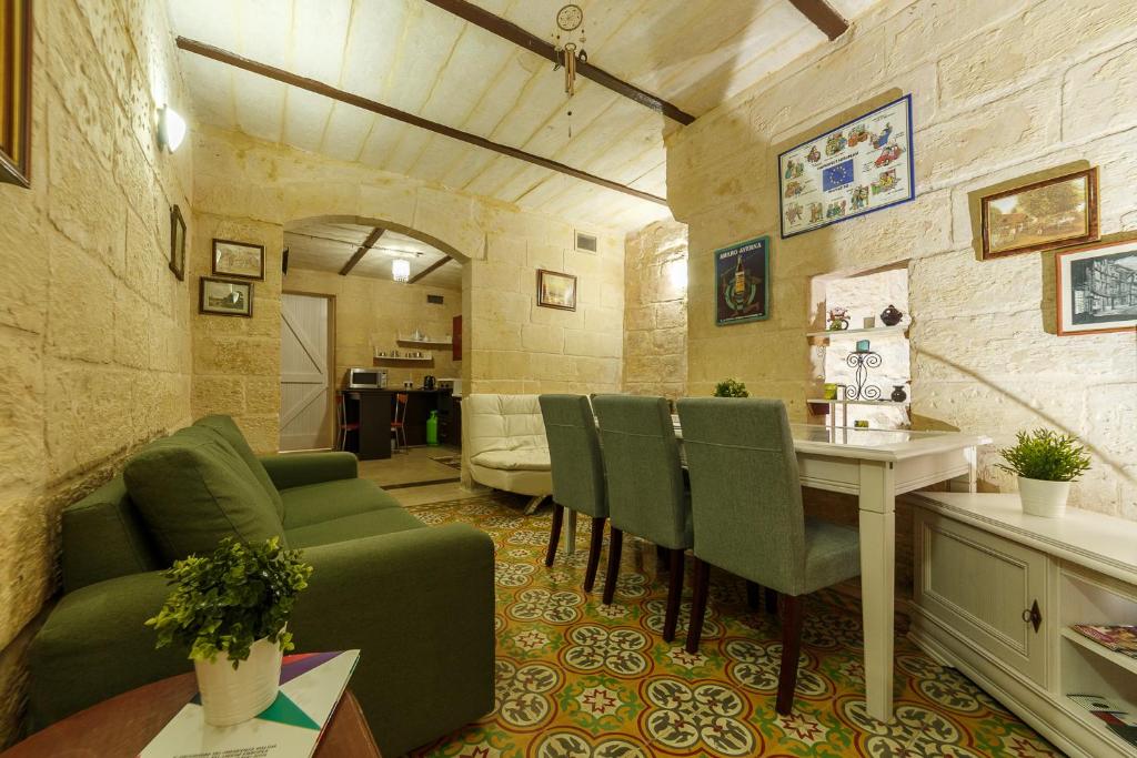 瓦莱塔Sant'Elmo House Valletta的客厅配有绿色沙发和桌子