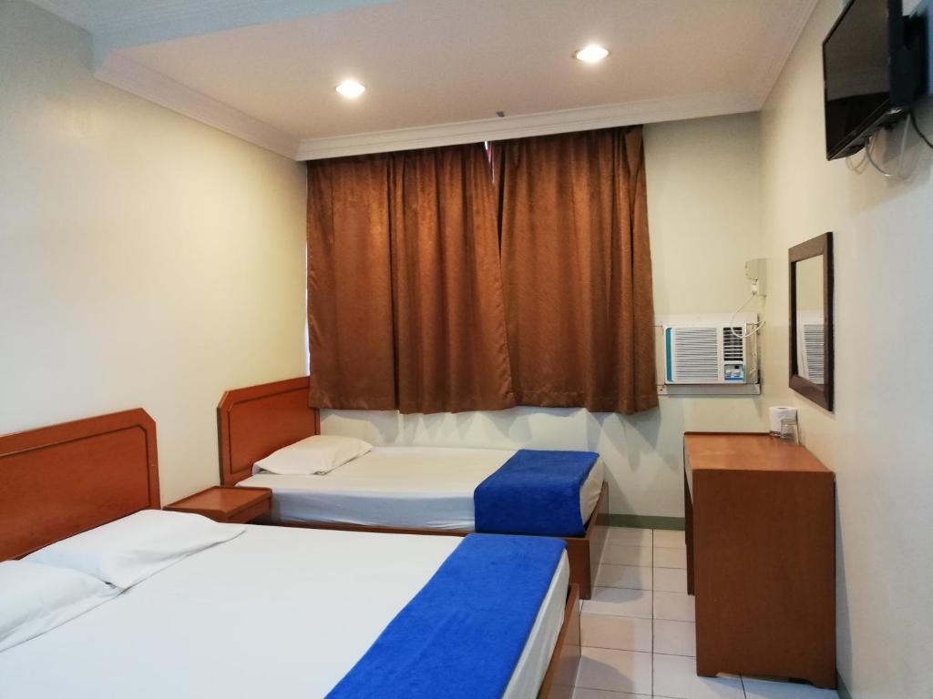 龙运Sri Gate Hotel的酒店客房设有两张床和窗户。
