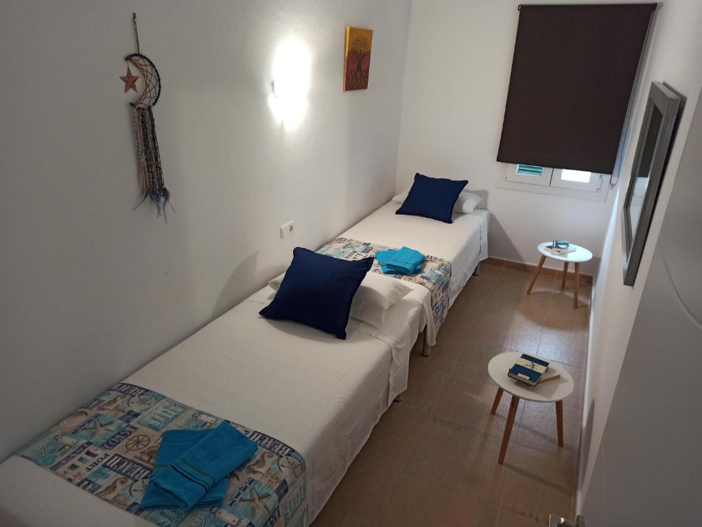 卡拉加尔达纳Garbí & Xaloc apartamentos的小型客房配有两张单人床和一张桌子。
