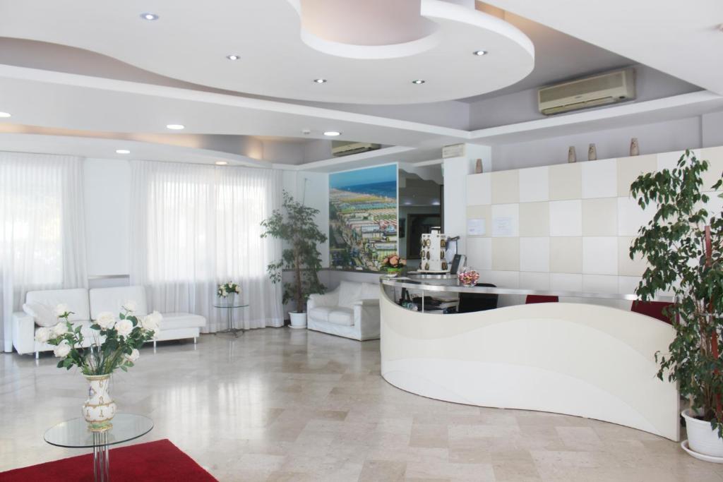 里米尼Hotel Marittima的客厅配有白色家具和植物