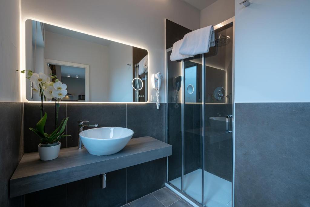 博洛尼亚Appartamenti Astoria的一间带水槽和玻璃淋浴的浴室