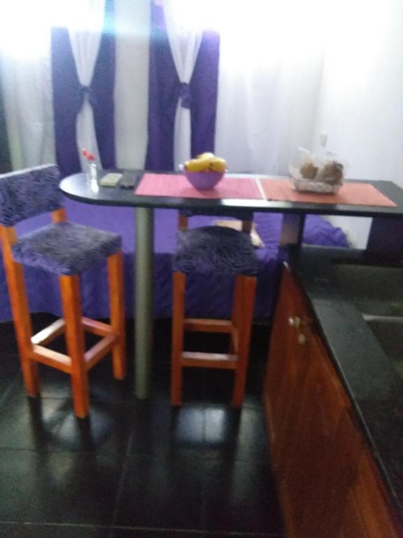 布宜诺斯艾利斯CHE LOLITA HOUSE的一张桌子,上面有两把椅子和一碗香蕉