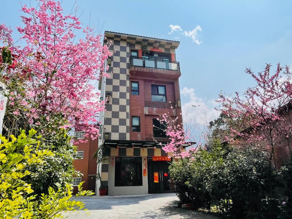 鹿谷乡新景宏渡假村的前面有粉红色花卉的建筑