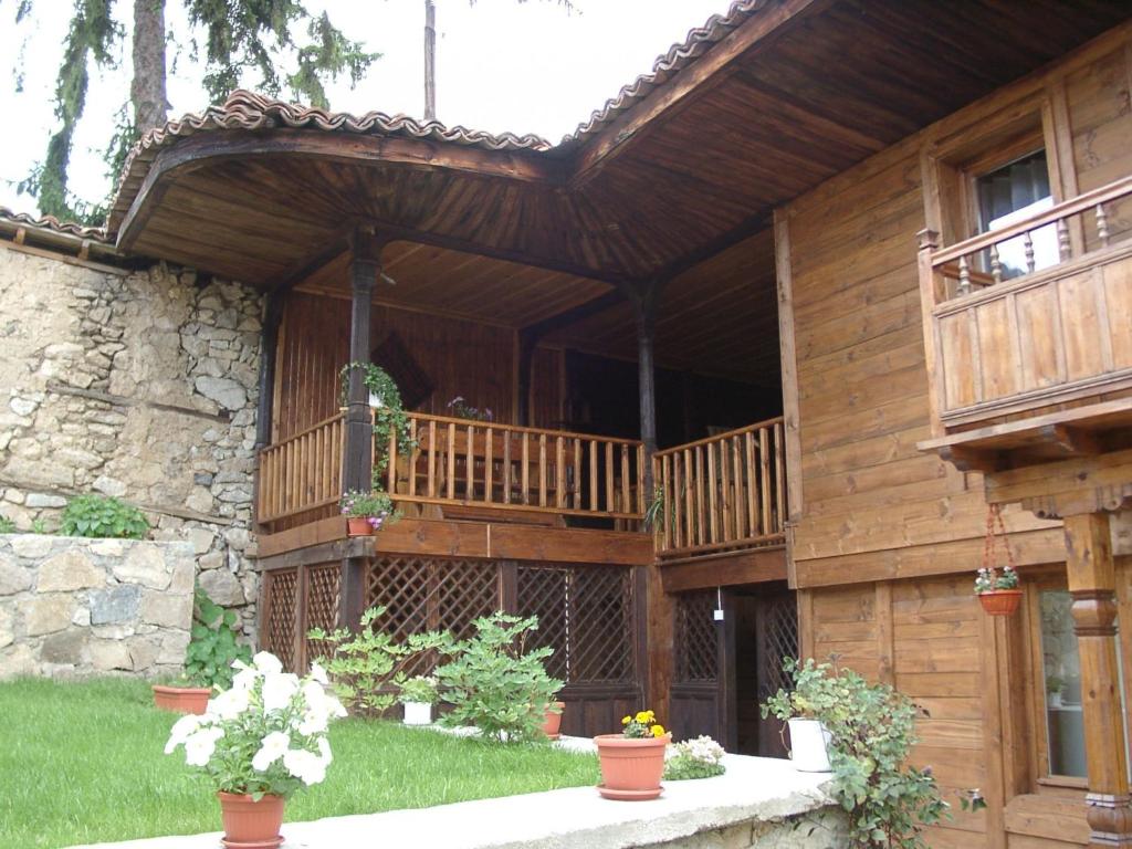 科普里夫什迪察Sarafova Guest House的带阳台和盆栽植物的木屋