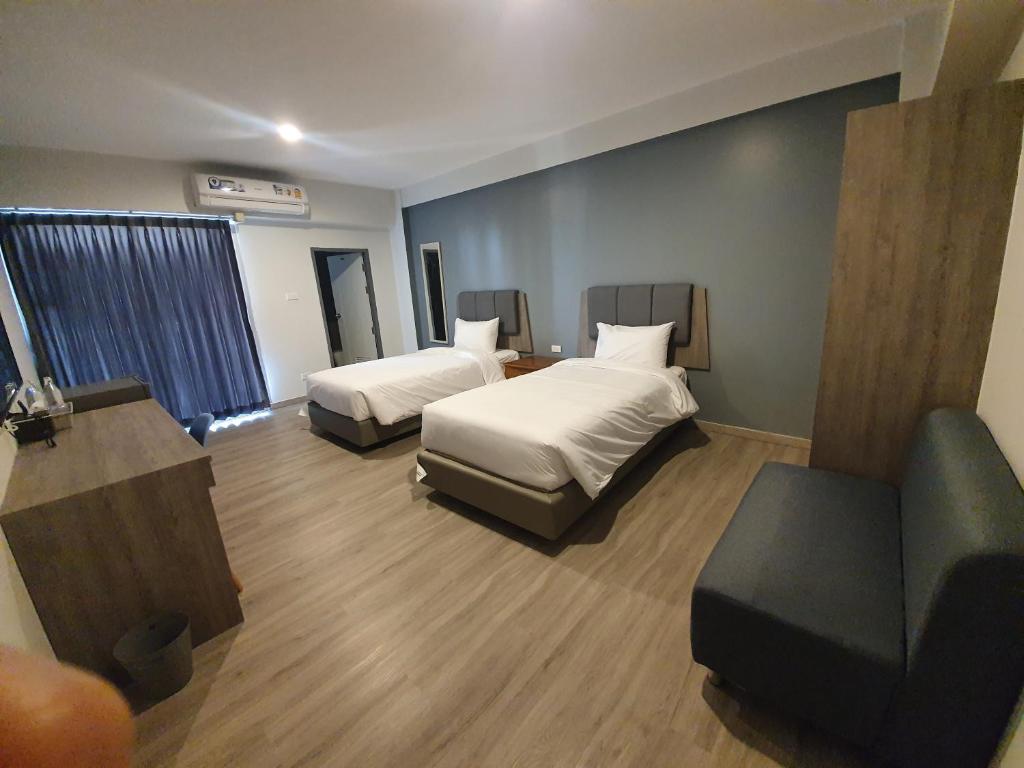 坤敬Neo Hotel的酒店客房,设有两张床和一张沙发