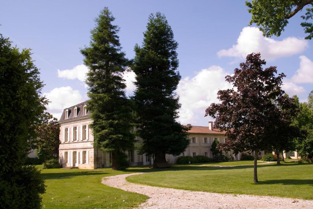 马尔戈Relais de Margaux - Hôtel & Spa的一座大白色房子,前方有树木
