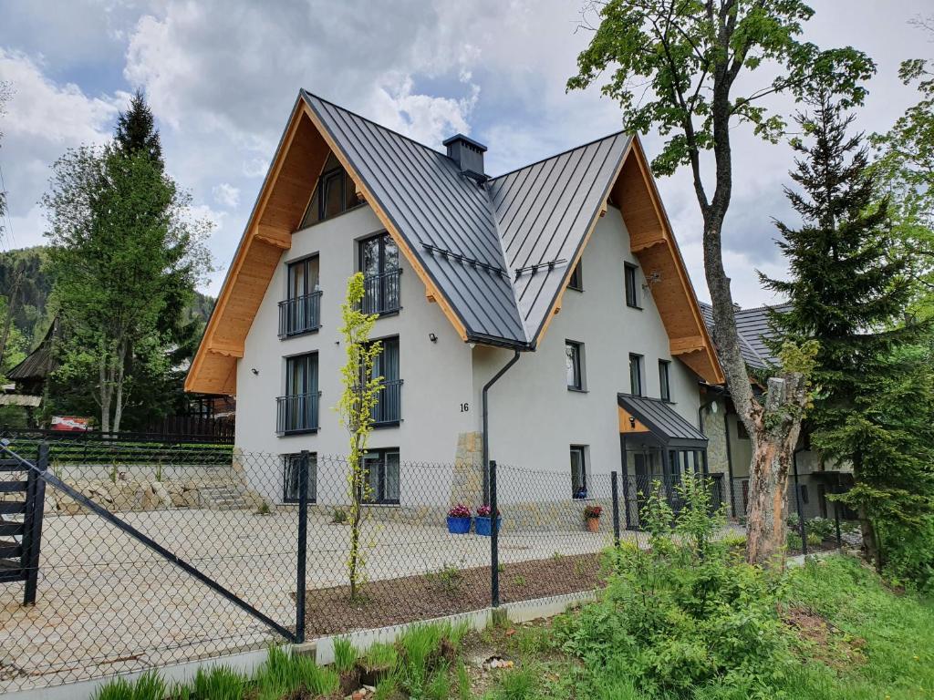 扎科帕内Pokoje na Buńdówkach的一间白色的房子,有金属屋顶