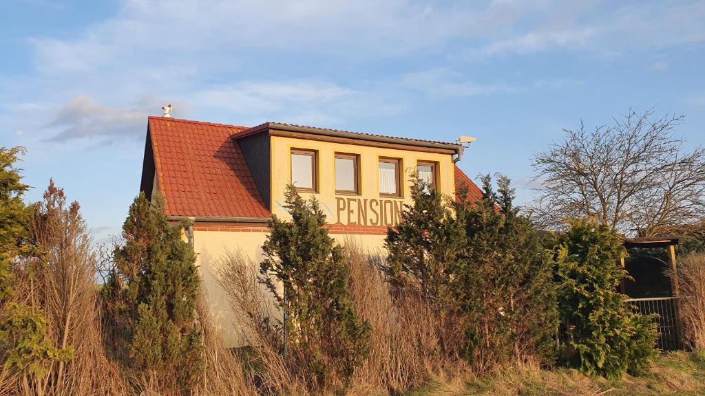 本特维施Pension Küstenkind的黄色房子的一侧有标志