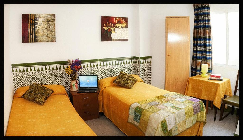 阿尔么丽亚车站旅馆的酒店客房设有两张床和一张书桌上的笔记本电脑