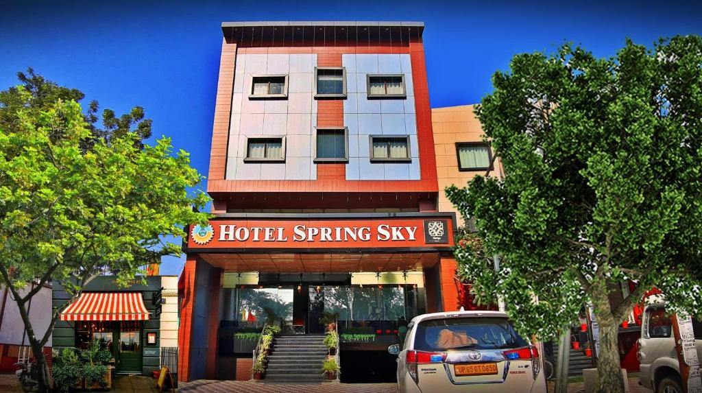 Mughal SarāiSpring Sky Mughalsarai By ShriGo Hotels的前面有酒店春天风格的标志的建筑