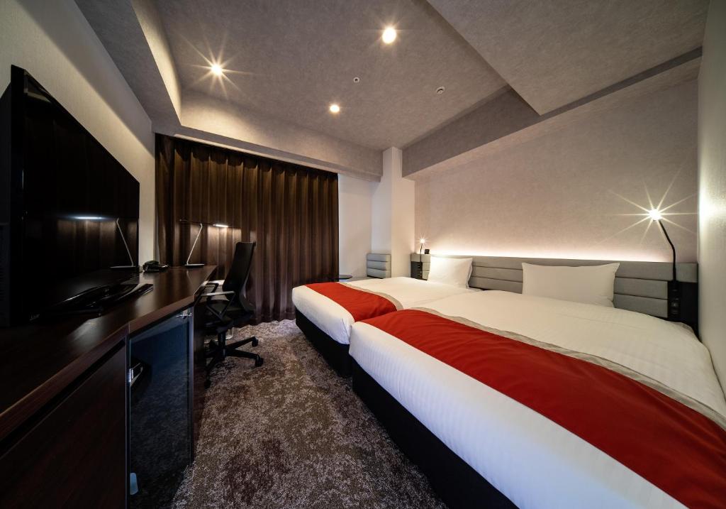 东京DEL style Ikebukuro Higashiguchi by Daiwa Roynet Hotel的酒店客房设有一张大床和一台电视。