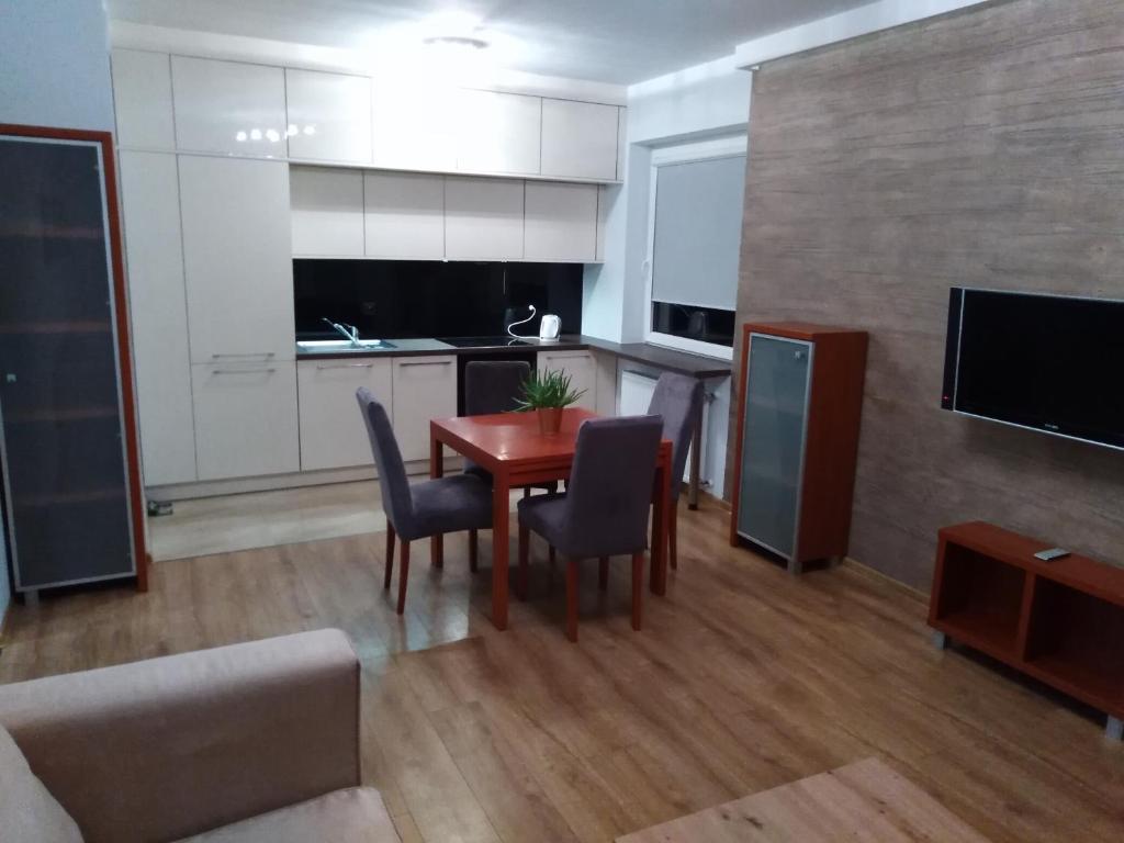 厄尔科Apartament MAZURIA2的厨房以及带桌椅的用餐室。