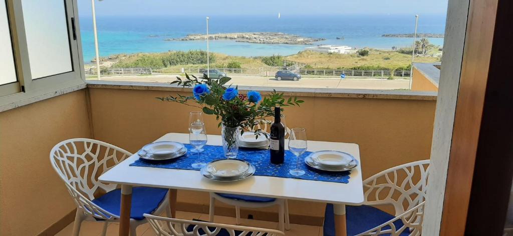 奥特朗托Bilocale Punta Rosa - Fronte Spiaggia的一张白色的桌子,上面有花瓶