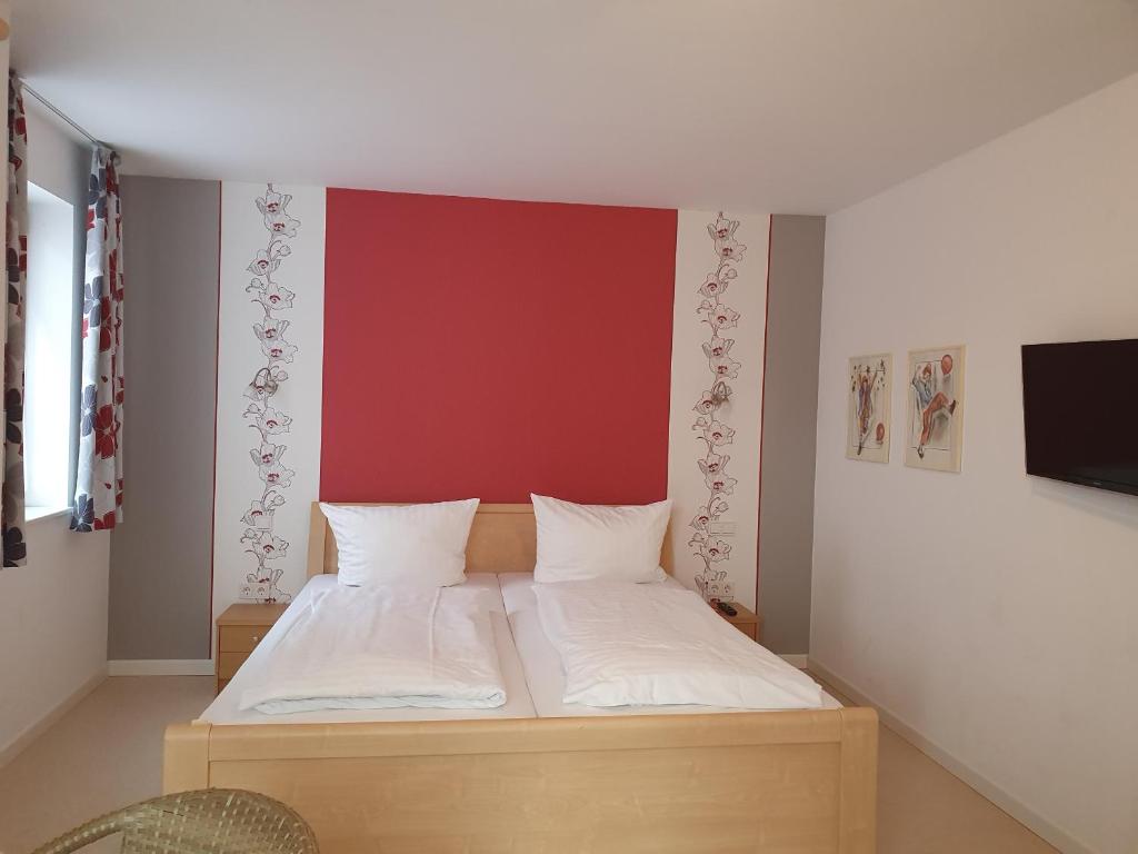 里尔Gästehaus Altstadttraum的一间卧室配有一张红色墙壁的床
