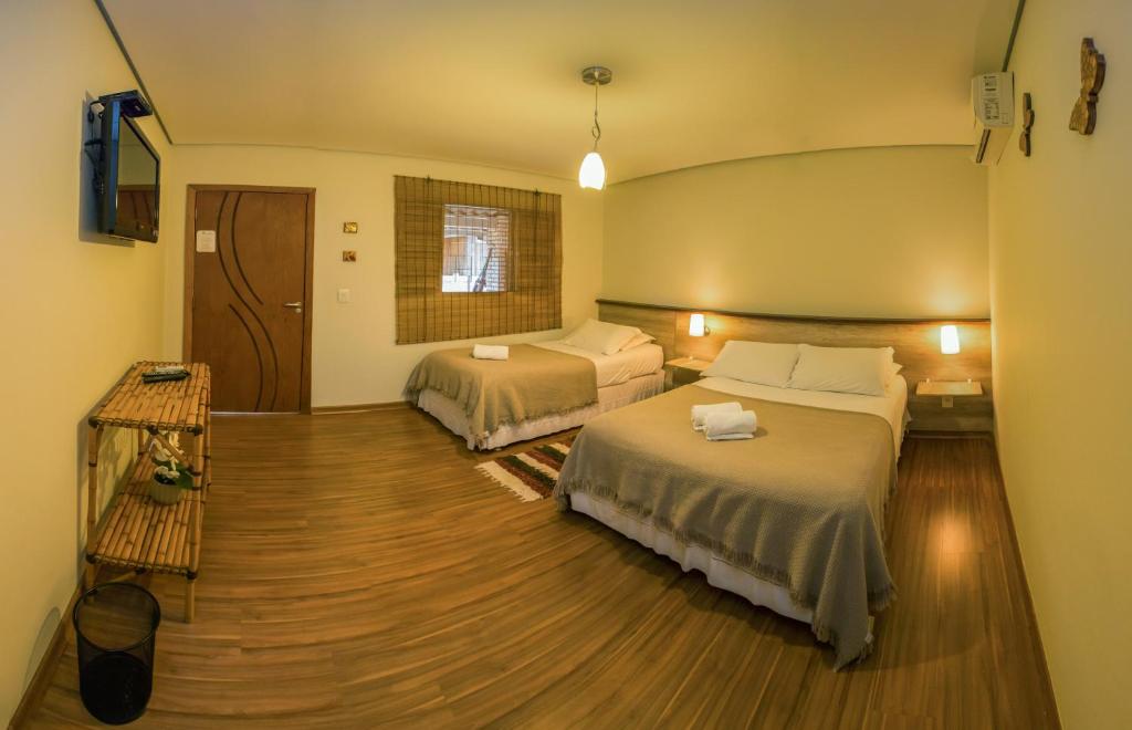 沙帕达-杜斯吉马朗伊斯Pousada Vento Sul的酒店客房设有两张床和电视。