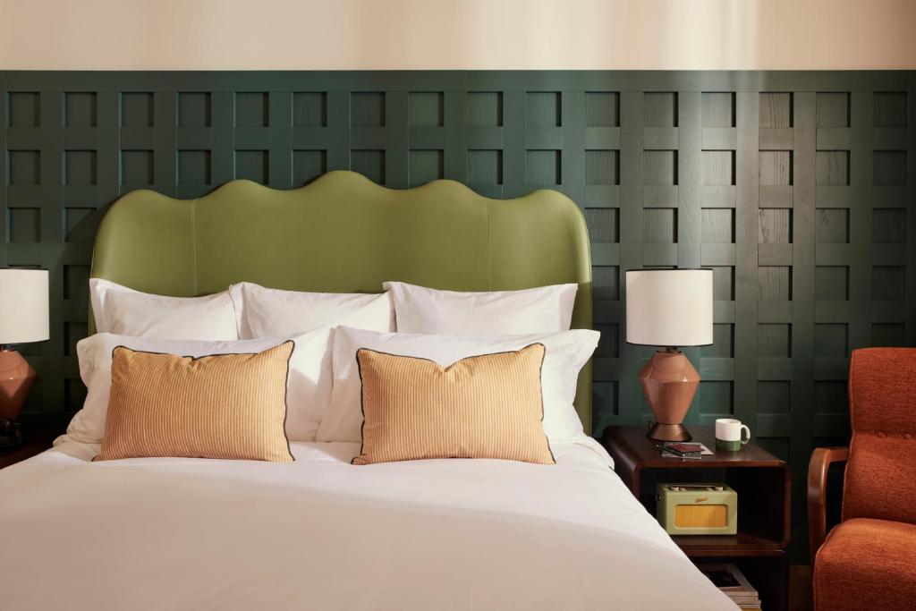 罗马The Hoxton, Rome的一间卧室配有一张大床和绿色床头板