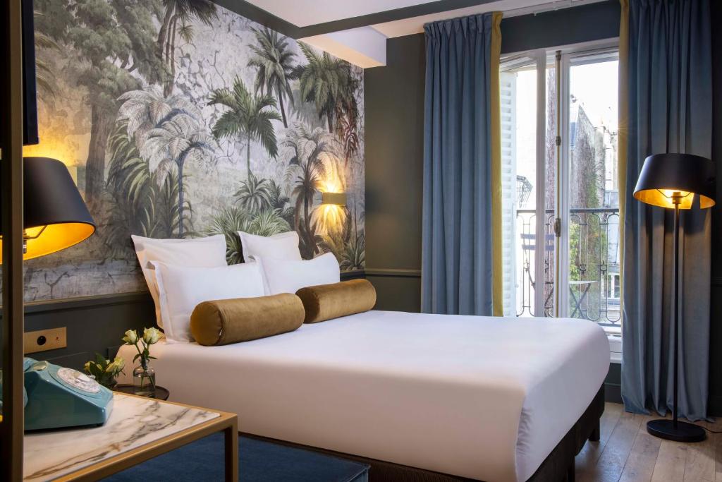 巴黎卢森堡花园酒店的一间卧室设有一张大床和一个大窗户