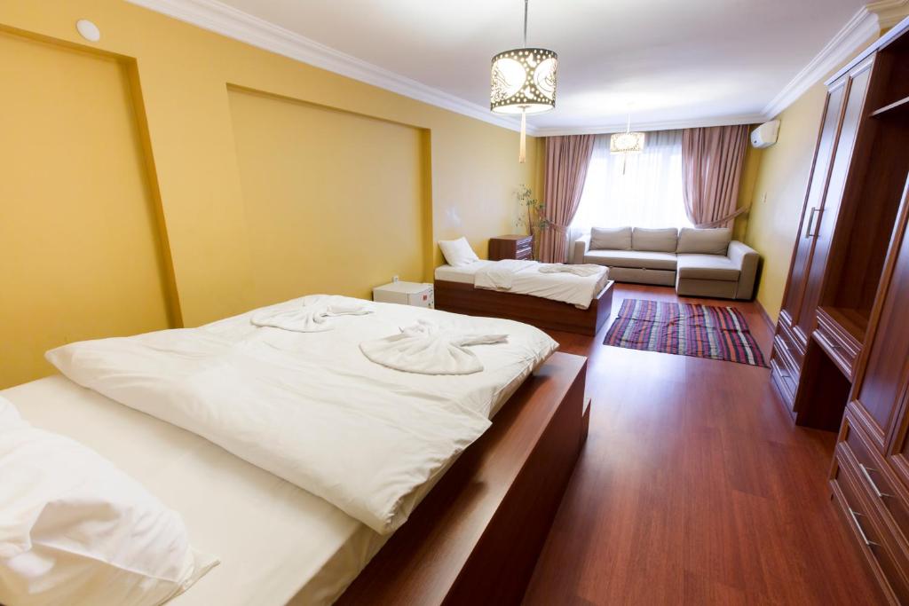 伊斯坦布尔istanbul enjoyer suit的酒店客房,设有两张床和一张沙发
