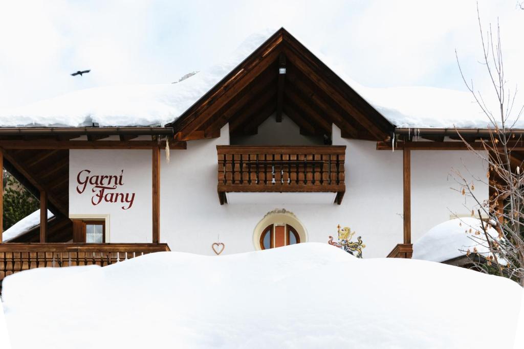科尔福索Garni Fany的雪覆盖的房子,上面有标志