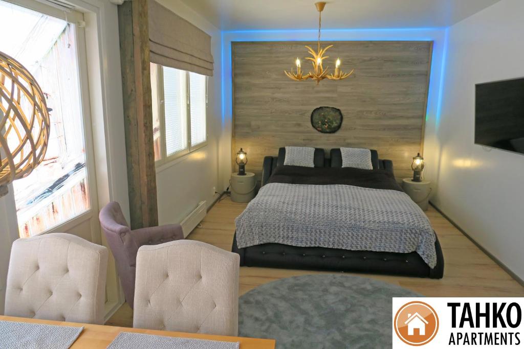 塔库沃里Apartments Huili的一间卧室配有一张床和两把椅子