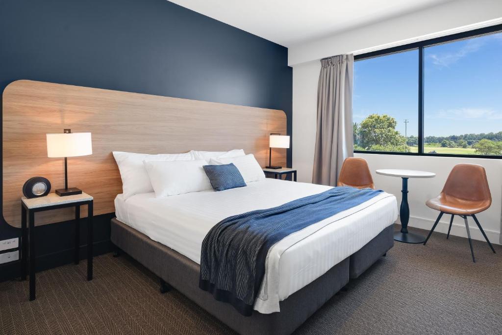 纽卡斯尔Springs Newcastle的酒店客房设有一张床和一个大窗户
