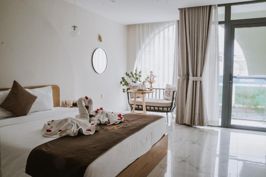 岘港Maple Suite Hotel & Apartment的一间卧室配有一张床、一张桌子和一个窗户。