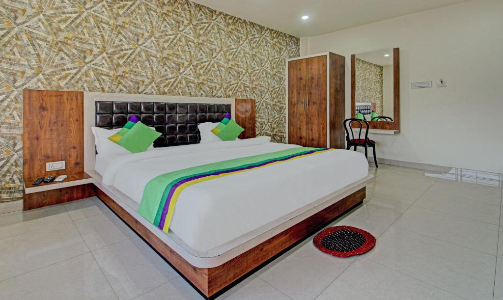 贾姆谢德布尔Treebo Trend Golden Heights的一间卧室配有一张大床和木制床头板
