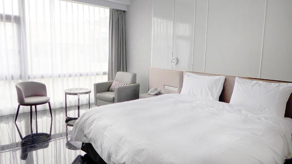 花莲市玫瑰香榭饭店的卧室配有一张白色大床和一把椅子