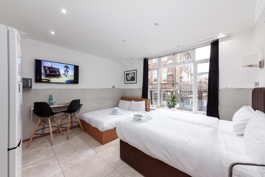 伦敦Argyle Apart Hotel的酒店客房配有两张床和一张书桌