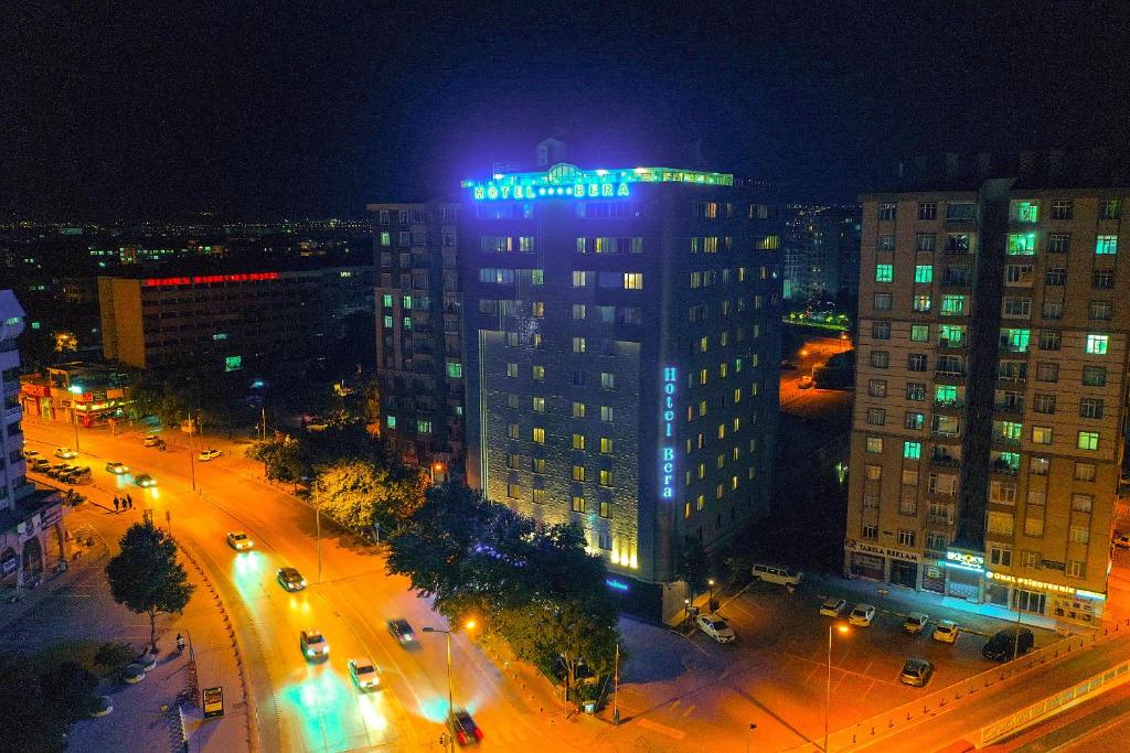 科尼亚科尼亚贝拉酒店的一座高大的建筑,上面有蓝色的标志,晚上