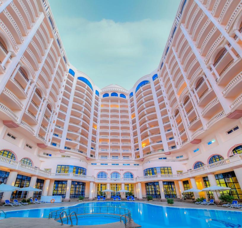 亚历山大亚历山大托里普酒店的一座大型建筑,前面设有一个游泳池